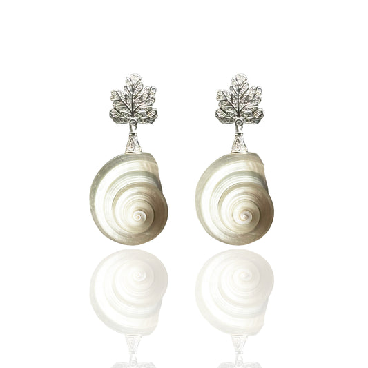 Pair of shell-shaped earrings with silver leaf-like tops on a white background