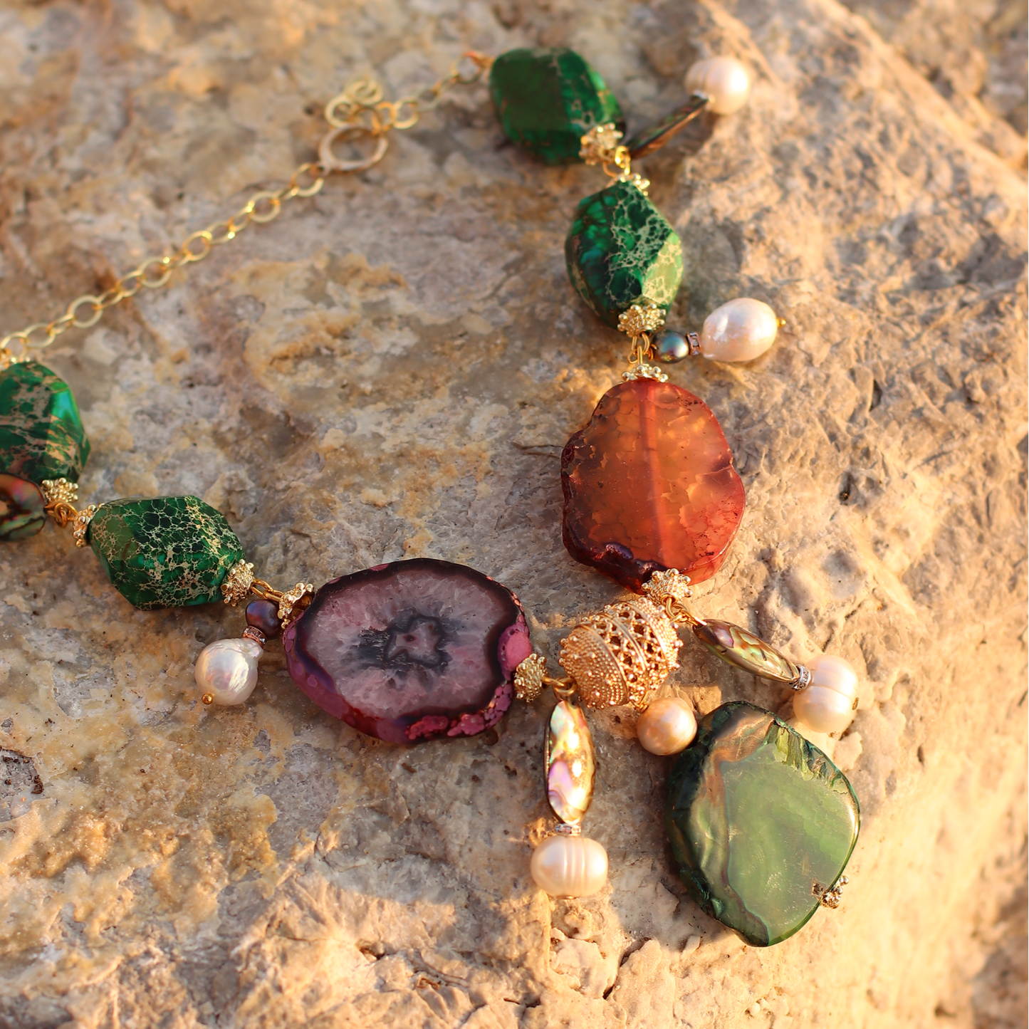 multicoloured_gemstone_necklace_with_pearls_on_the_rock